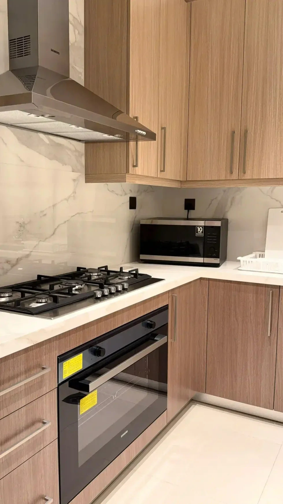 Kitchen with wood-grain cabinets and white marble-look tile backsplash